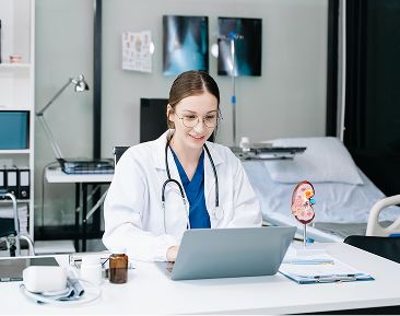 Healthcare provider working on a laptop with medical charts and equipment in the background