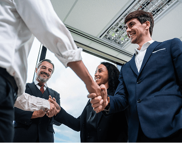 Business professionals greeting each other with a handshake in a modern office setting
